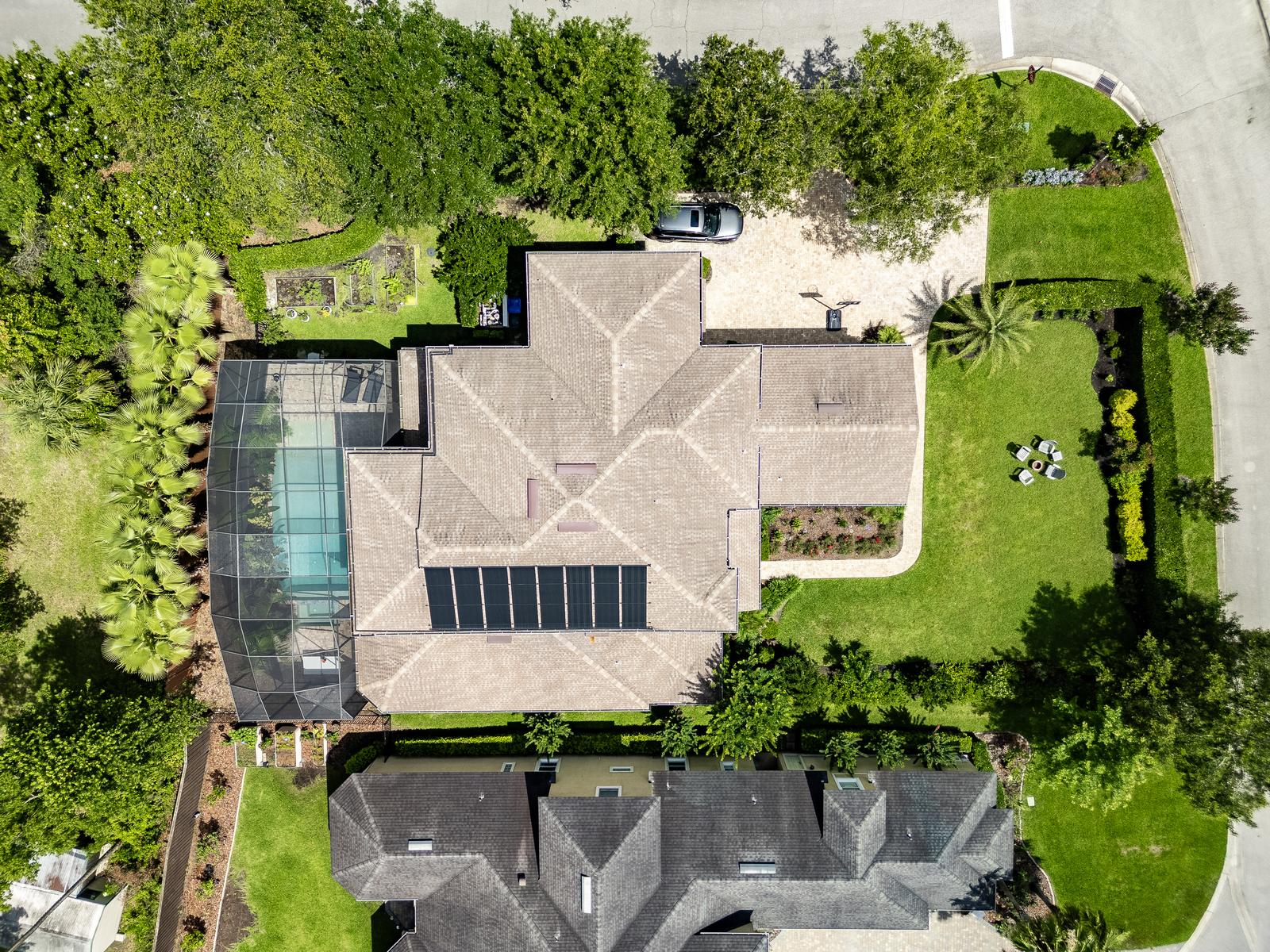 Aerial drone photo of a Ponte Vedra Beach FL home with screened pool enclosure and landscaped yard - a view no ground camera can capture