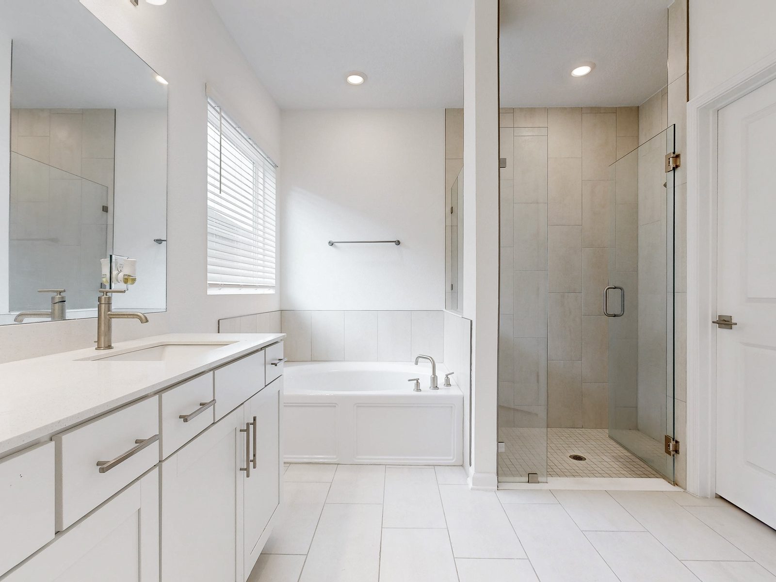 HDR photo of a bright primary bathroom with soaking tub and glass shower, exported from a Matterport 3D scan in Northeast Florida