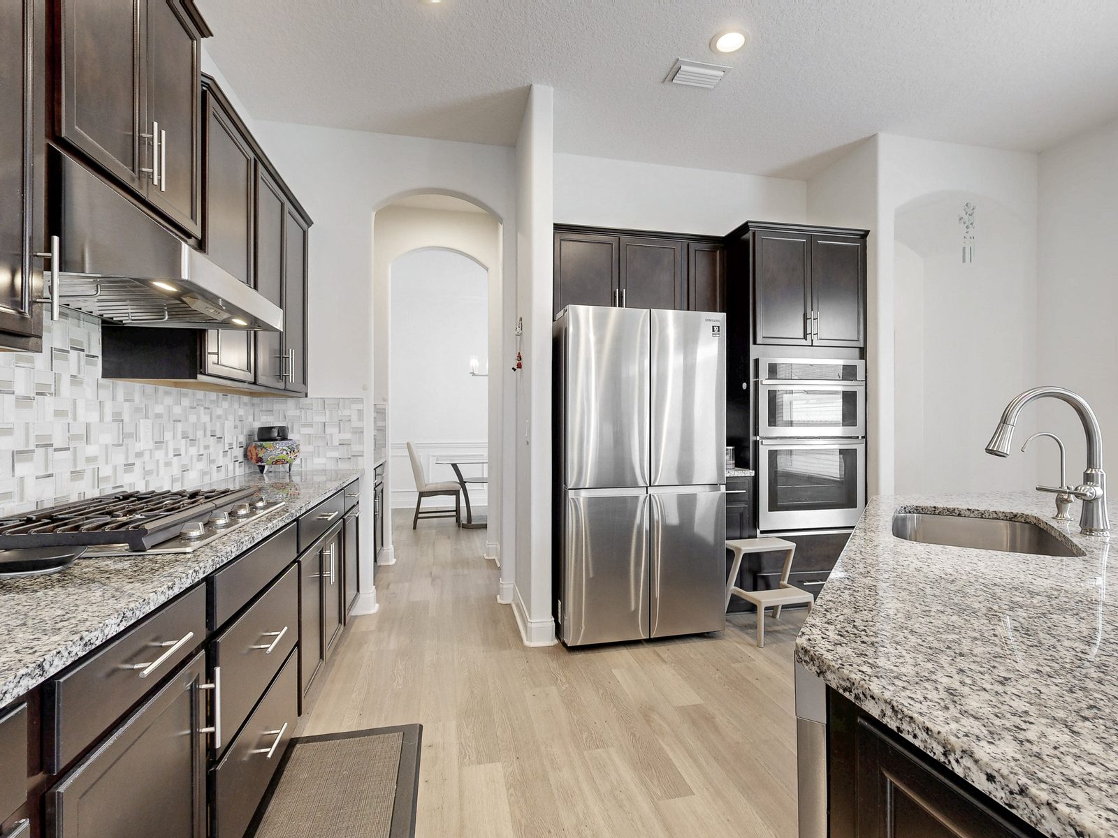 HDR listing photo of a kitchen with dark cabinets and granite counters, produced from a Matterport 3D scan in Jacksonville FL